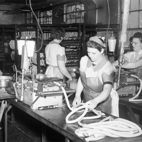 Four women operating sausage-making equipment at the Oscar Mayer Company during World War II.